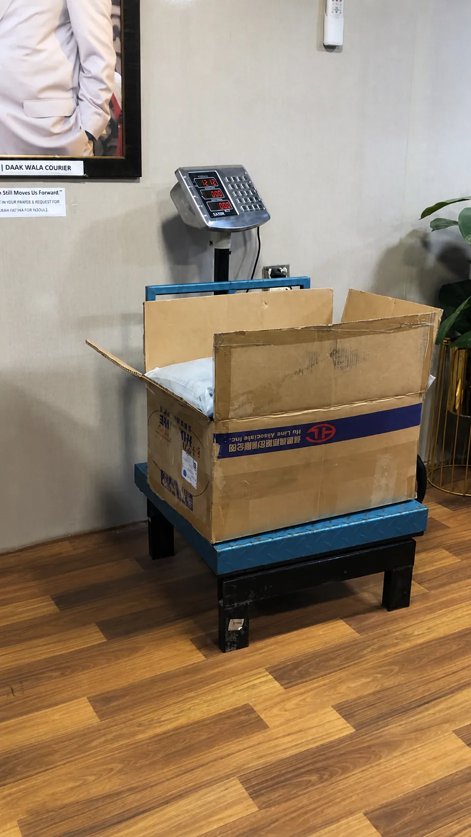 Packed export carton checked on a digital weighing platform