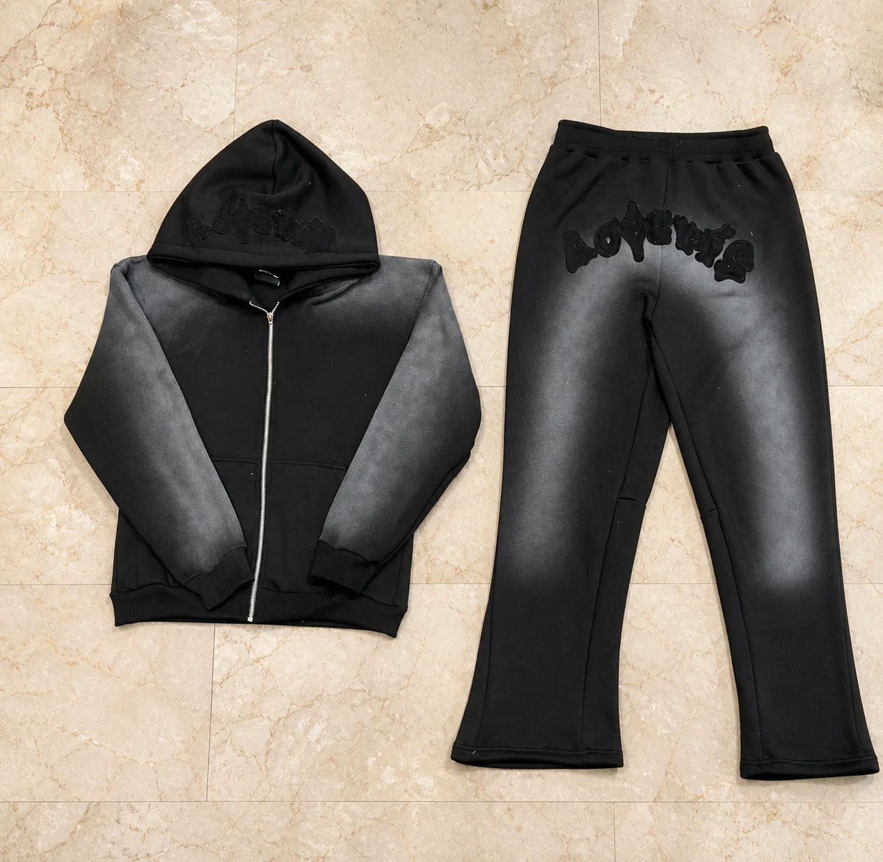 Black zip hoodie and trouser set with a grey spray-wash finish and tonal embroidery