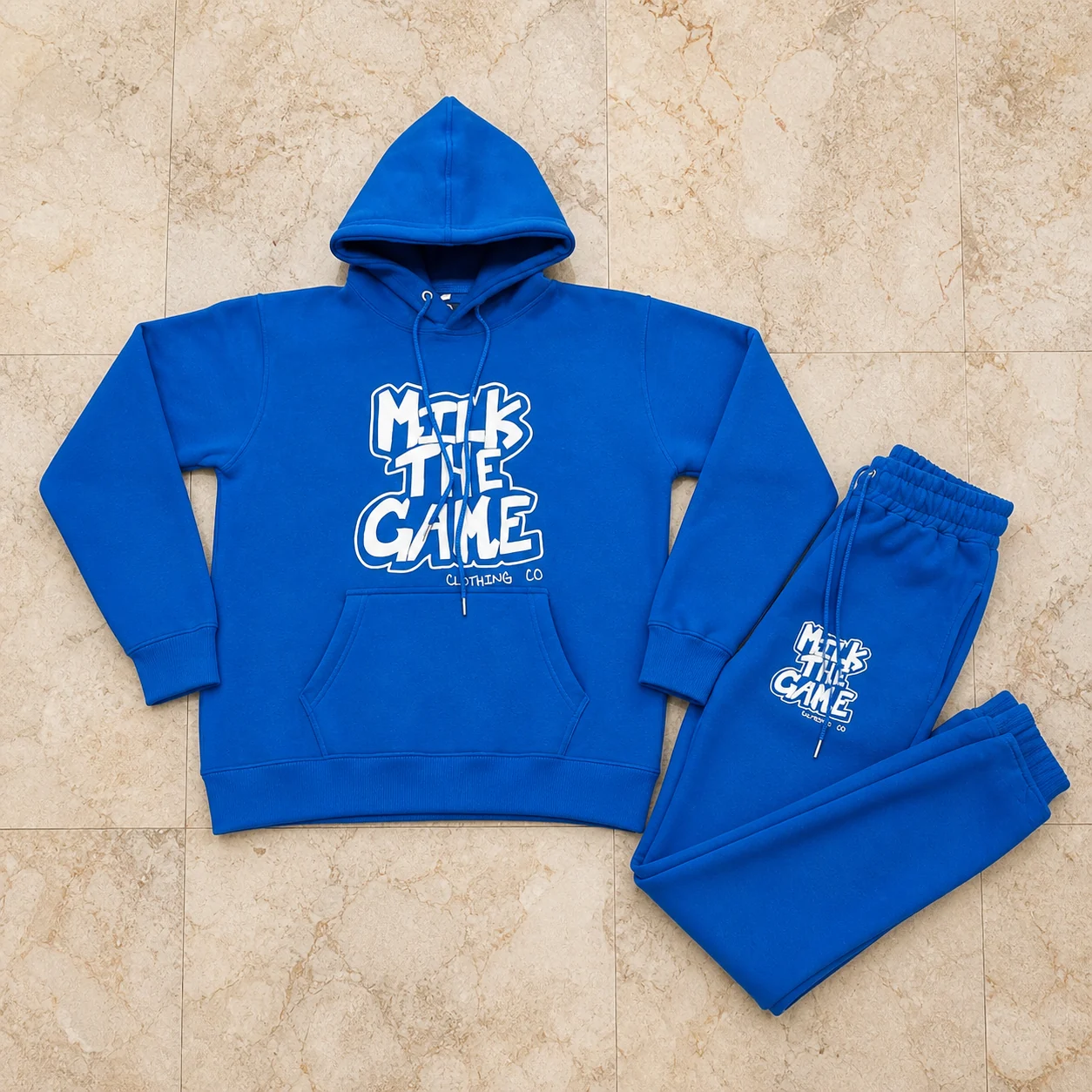 Royal blue graphic hoodie and trouser set arranged on marble