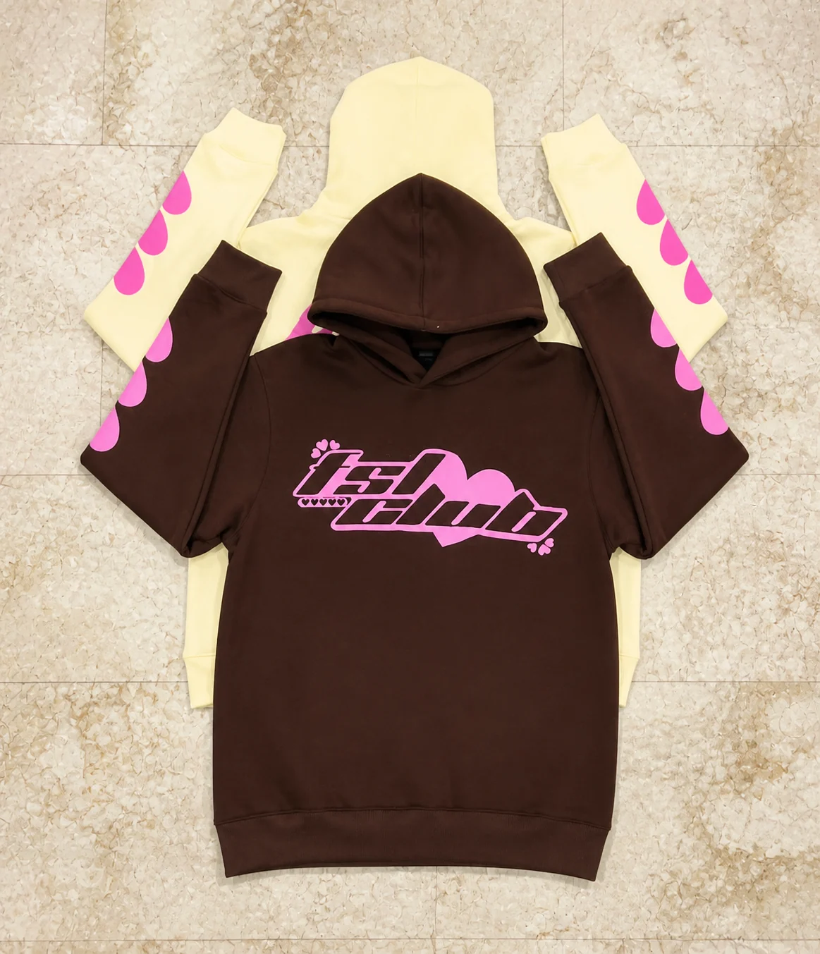 Brown and cream pullover hoodies layered together with pink printed graphics