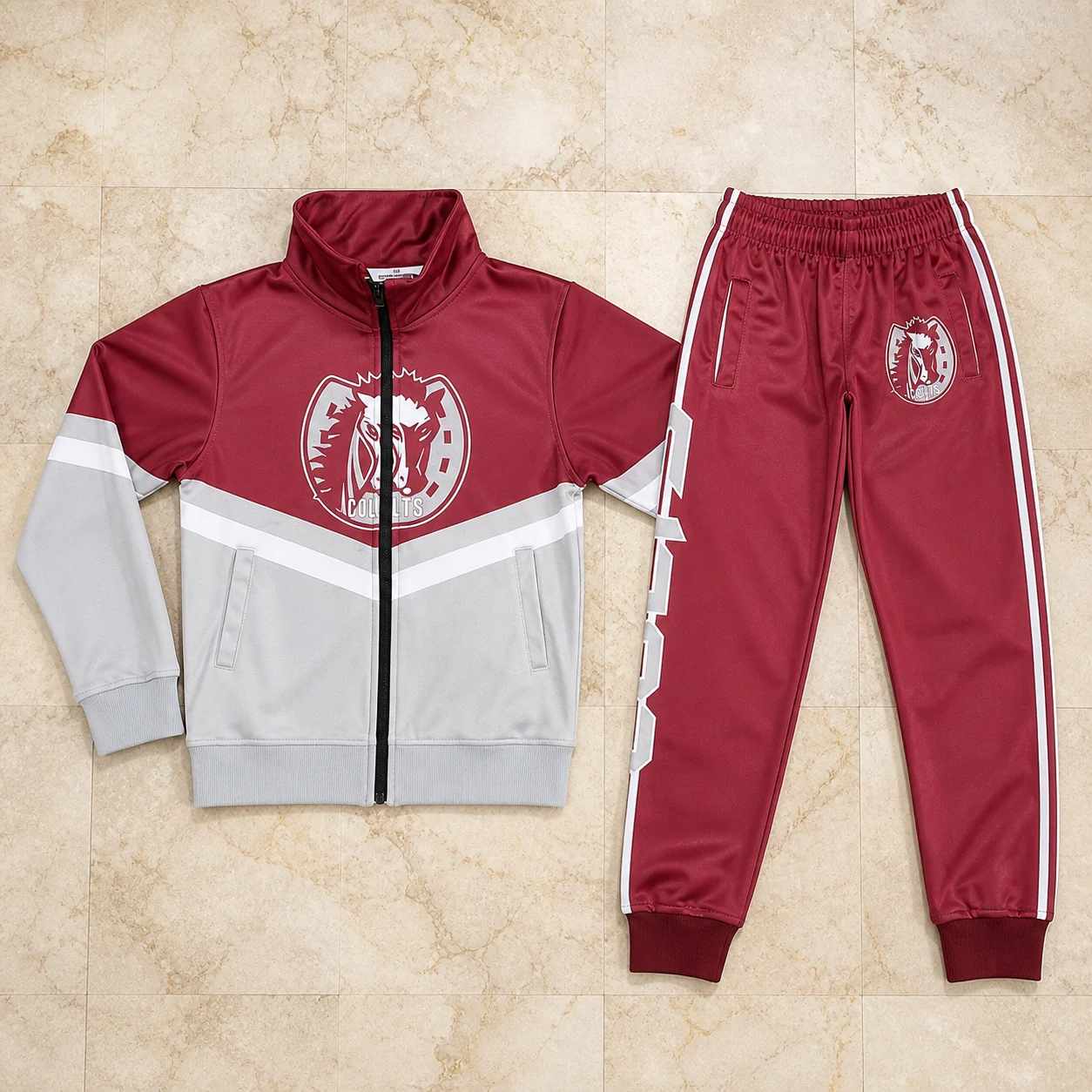 Red and grey color-block jacket and trouser set on marble
